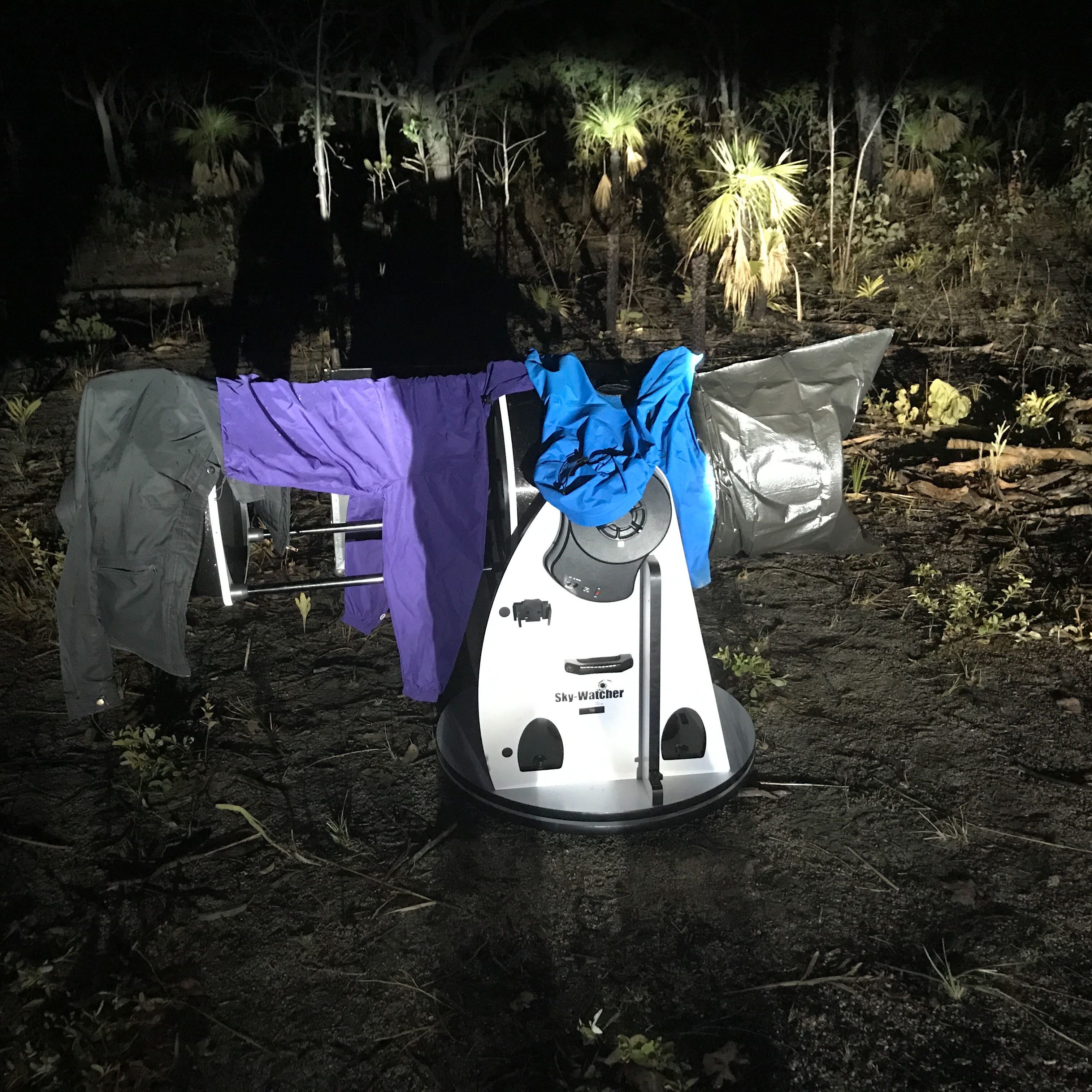 Unfortunately there was rain the night of the occultation.  David Vestal protects their telescopes as they hope for a break in the clouds.